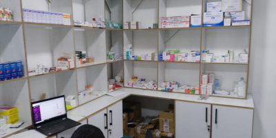 Pharmacy counter at Light Shepherd Hospital with medications and a pharmacist
