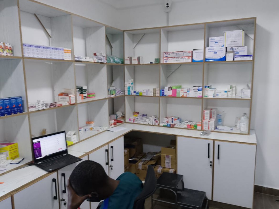 Pharmacy counter at Light Shepherd Hospital with medications and a pharmacist